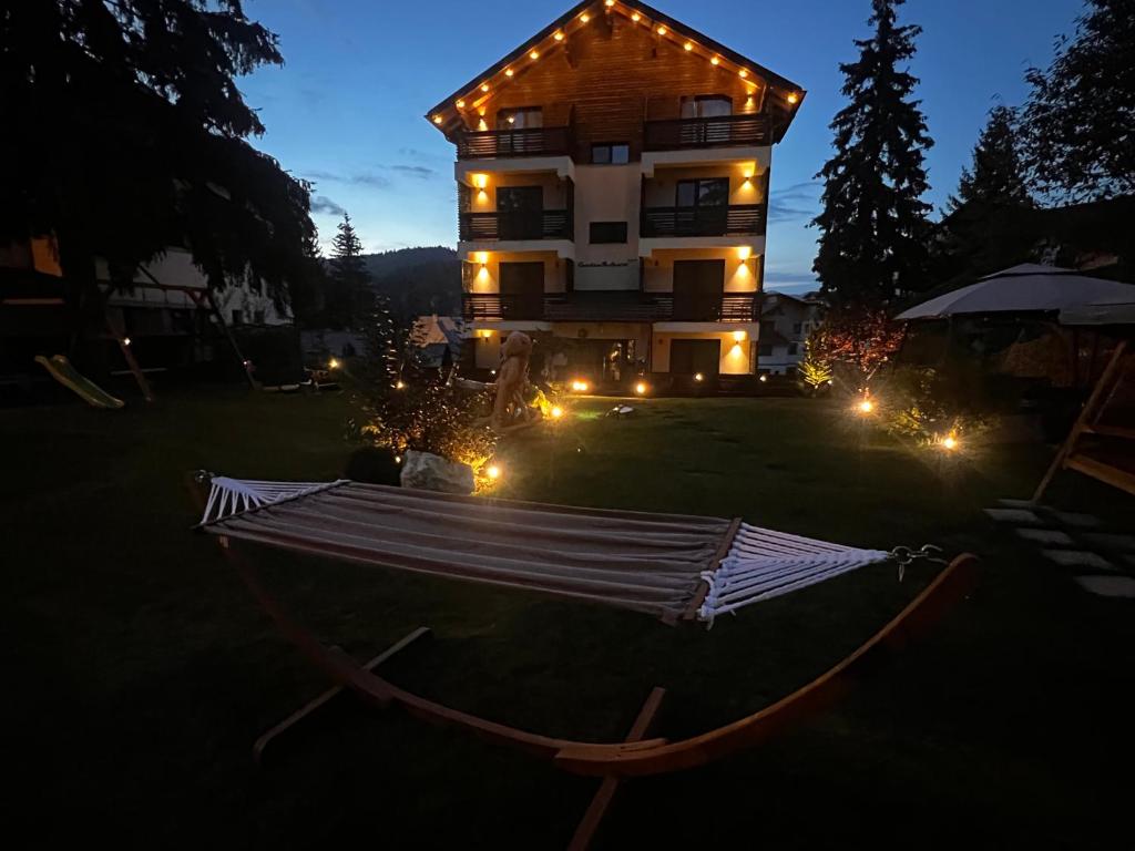 a house with lights in the yard at night at Garden Apart&Rooms Predeal in Predeal