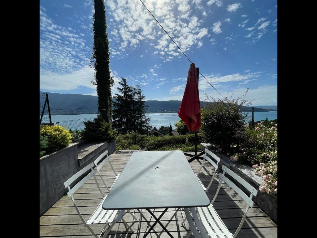 a table and an umbrella sitting on a patio at Cottage Bellevue - Duplex Vue Lac in Veyrier-du-Lac