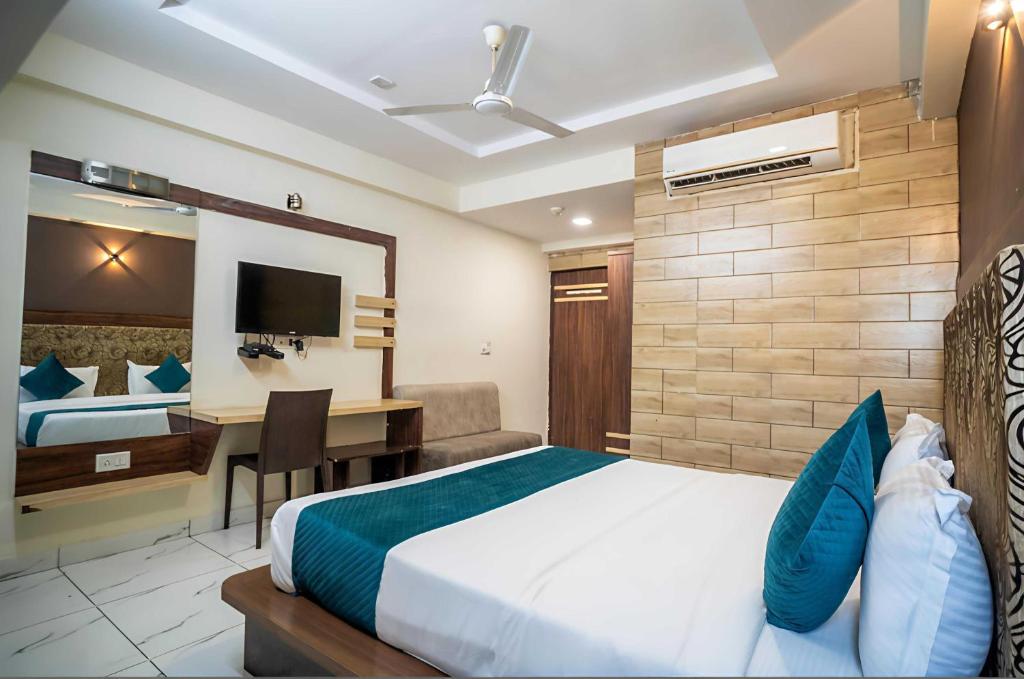 a hotel room with a bed and a desk and a bed at Hotel O Rajula Formerly The Urban Hotel in Rājula