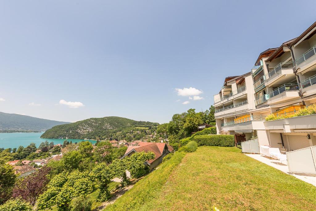 an apartment building with a view of the water at L'Arcadia Panoramique - Terrasse Vue Lac et Piscine in Talloires