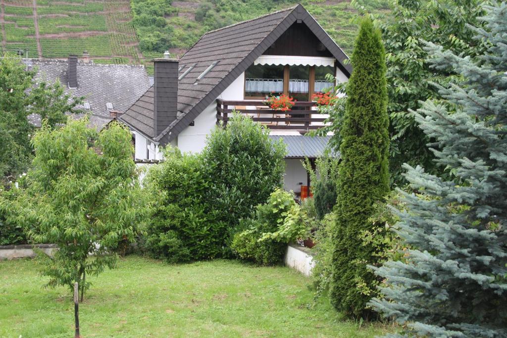 a small white house with a porch in a garden at FeWo Karola in Ellenz-Poltersdorf