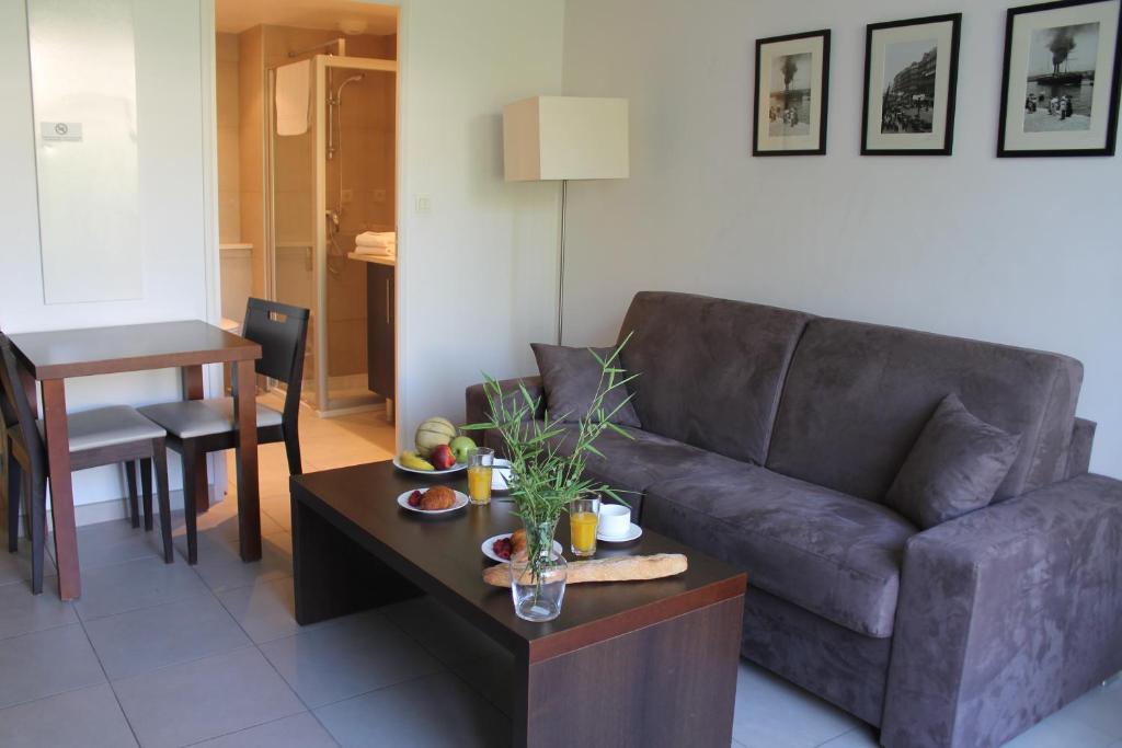 - un salon avec un canapé et une table dans l'établissement Residence Services Calypso Calanques Plage, à Marseille