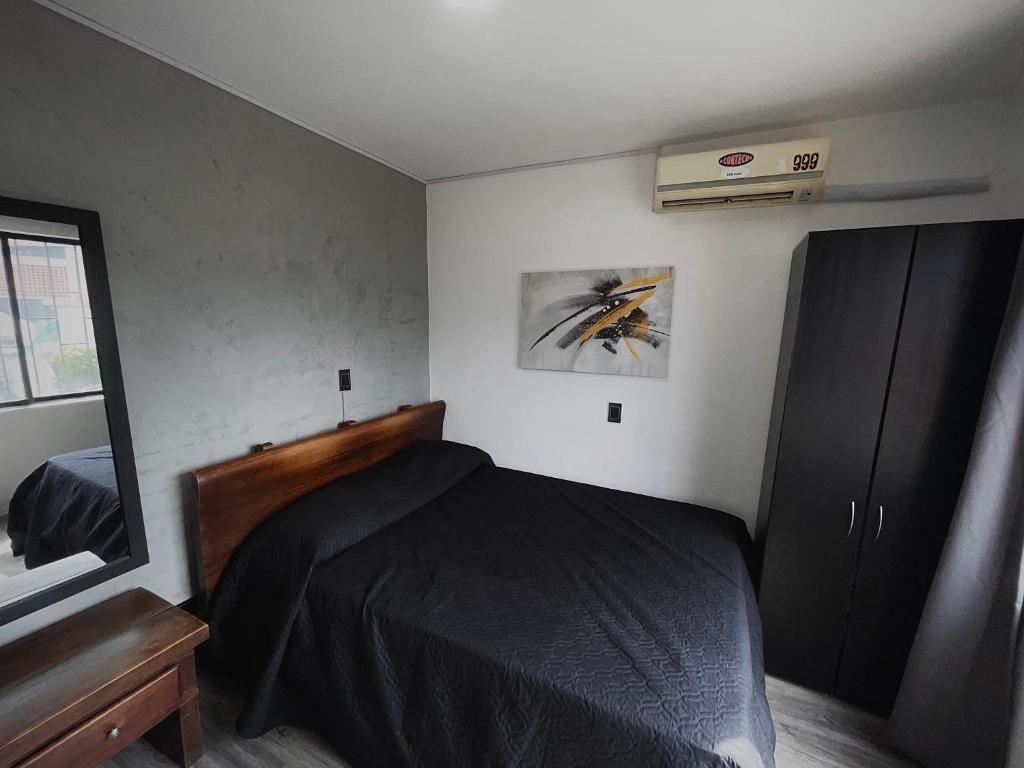 a small bedroom with a bed and a window at Espectacular apartaestudio en envigado cerca de todo in Envigado