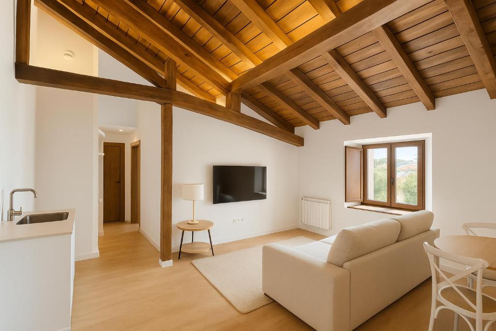 a living room with a couch and a tv at Otero de Campoo Apartamentos in Espinilla