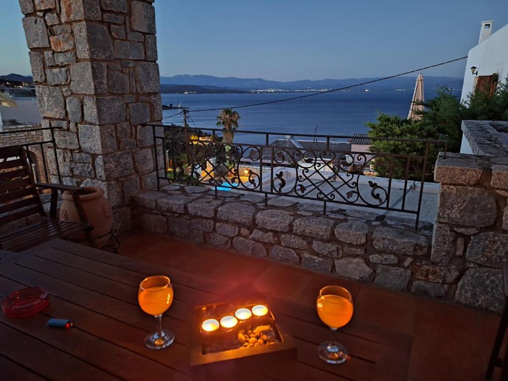 a table with candles and wine glasses on a balcony at Malvazios Villas #5 in Gythio