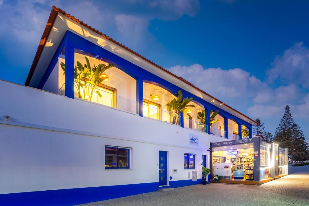 ザンブジェイラ・ド・マールにあるAlojamento Costa Alentejanaの青色のアクセントが施された白い大きな建物