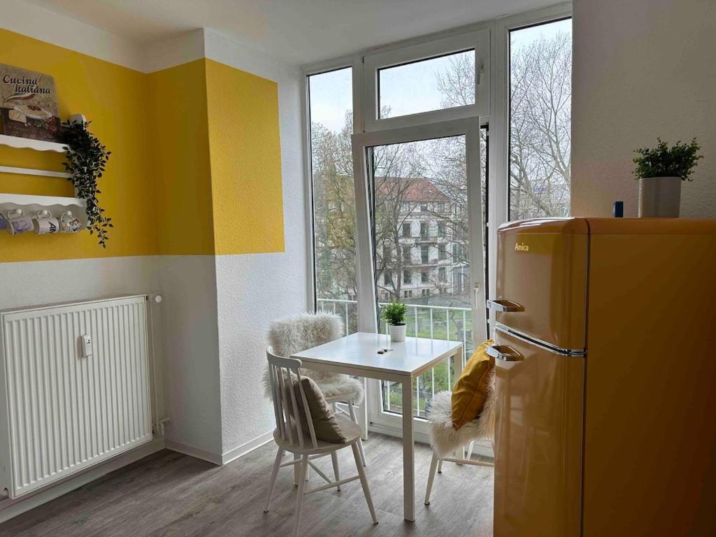 a kitchen with a refrigerator and a table and a window at Gemütliches City-Apartment in Top-Lage Hannover in Hannover