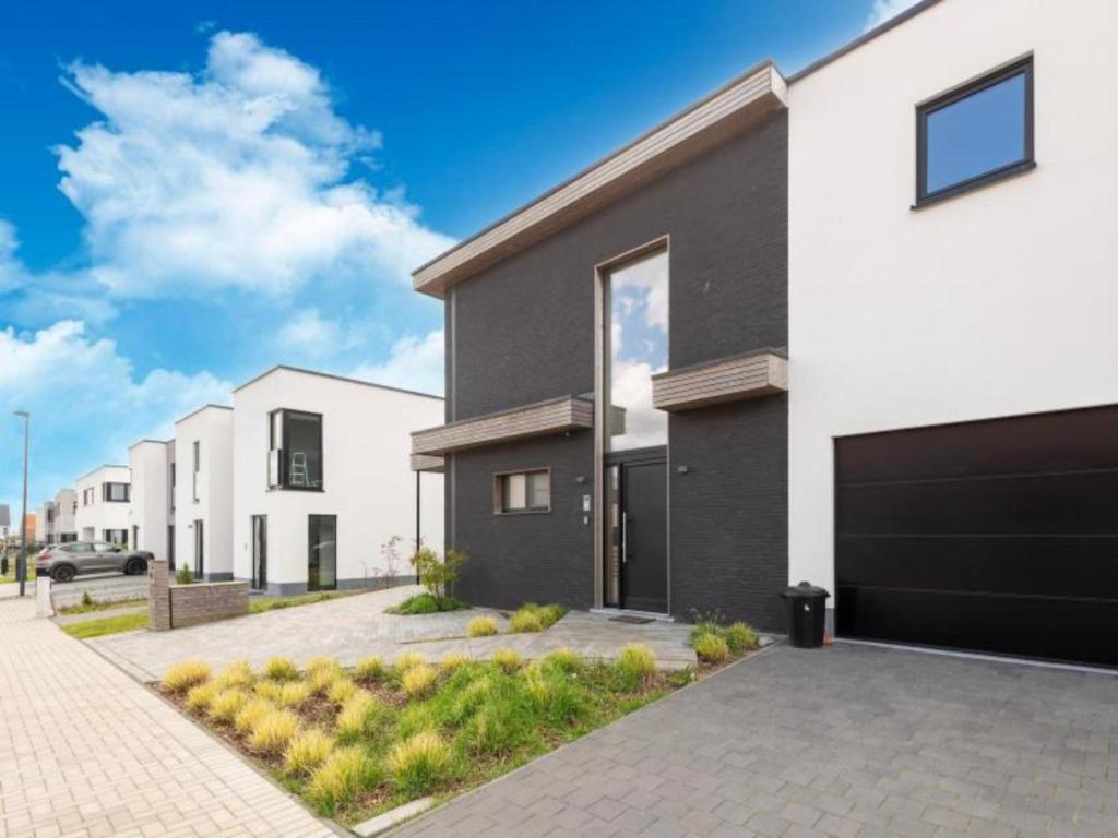 ミッデルケルケにあるKruiers Eco Lodgeの私道付白黒家