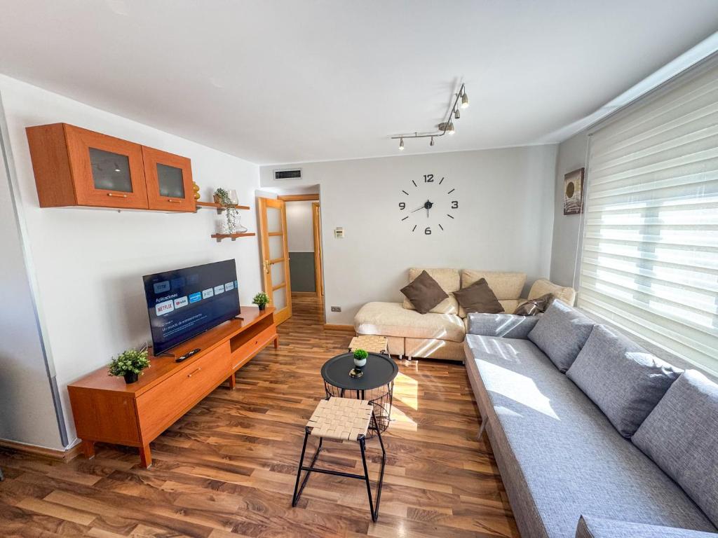 een woonkamer met een bank en een tv bij Cineasta del Pilar - Turistea in Zaragoza