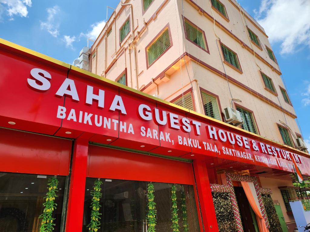 un edificio con un cartello per una pensione di Saha Guest House & Restaurant a Krishnanagar