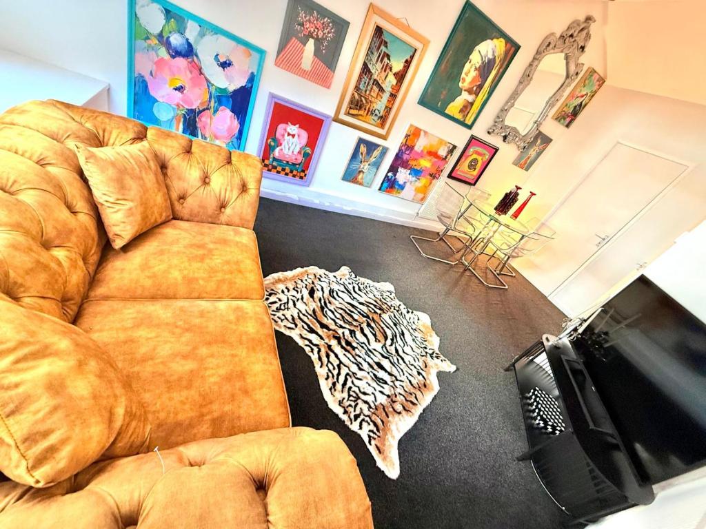 a living room with a couch and a television at Designer 2-Bed Flat by Tower Bridge in London