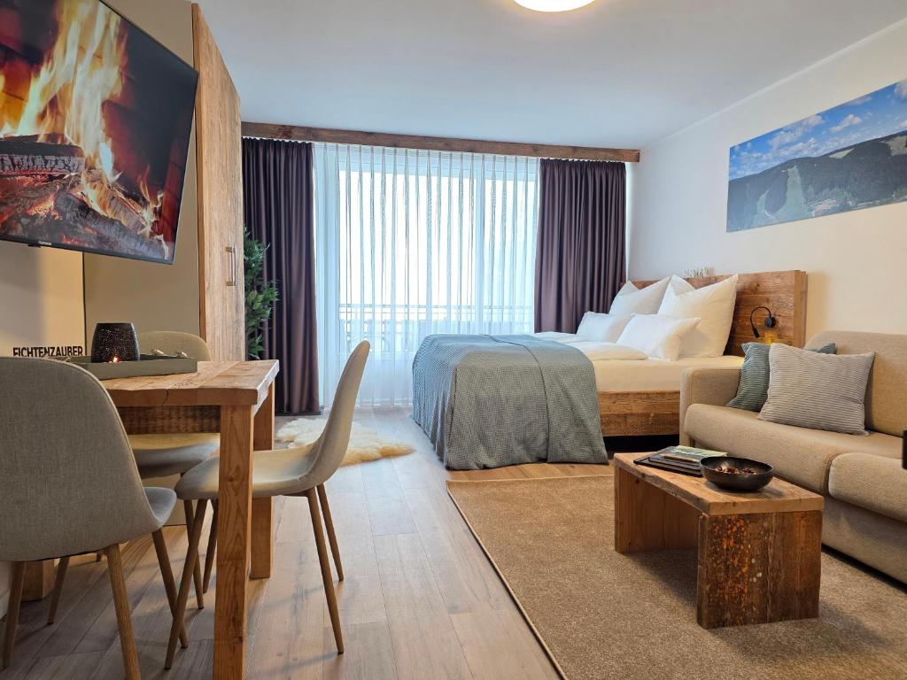 a bedroom with a bed and a living room at Ferienwohnung Fichtenzauber mit Balkon, nahe Bikepark & Skipiste in Winterberg