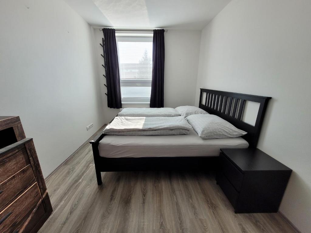 a small bedroom with a bed with a window at Apartmán Neva Galanta 2 in Galanta