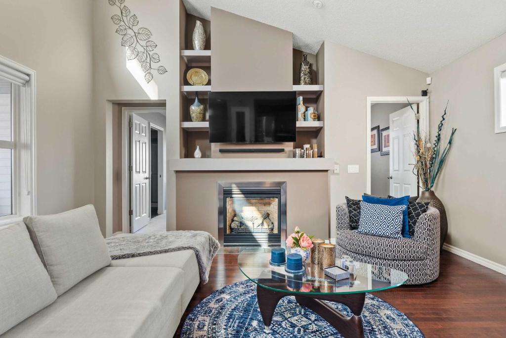 a living room with a couch and a fireplace at Large Family 4 BR Entire Home w Kid's Play Tent! By Airport - FREE Banff Pass, Wine, Gym, Netflix, BBQ! in Calgary