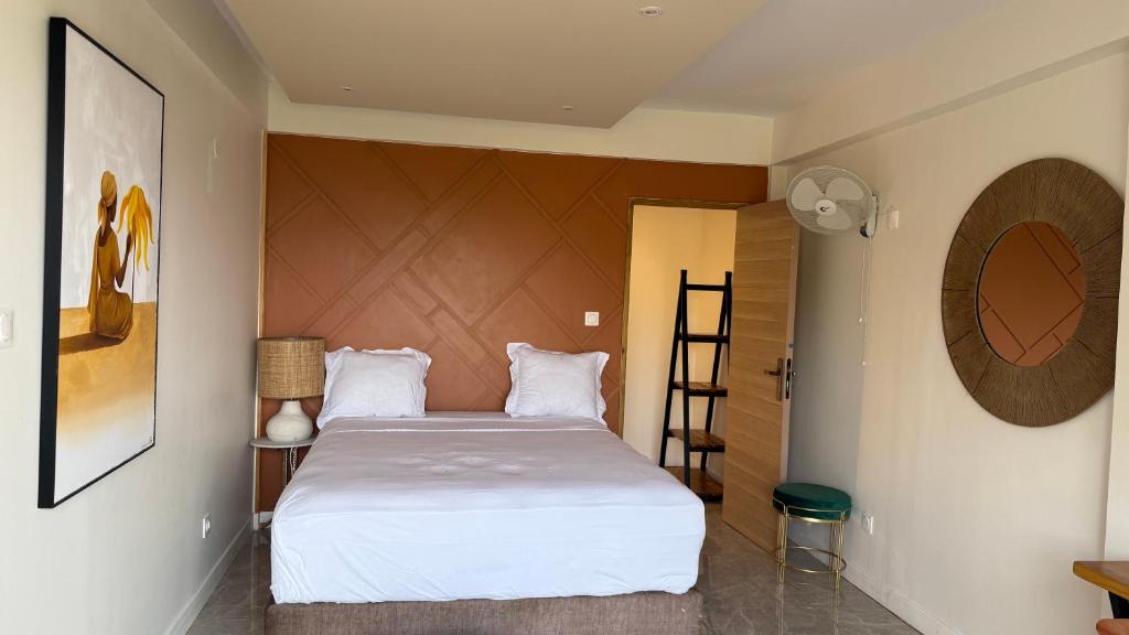 Un dormitorio con una gran cama blanca en una habitación. en Résidence Kazela, en Chirongui
