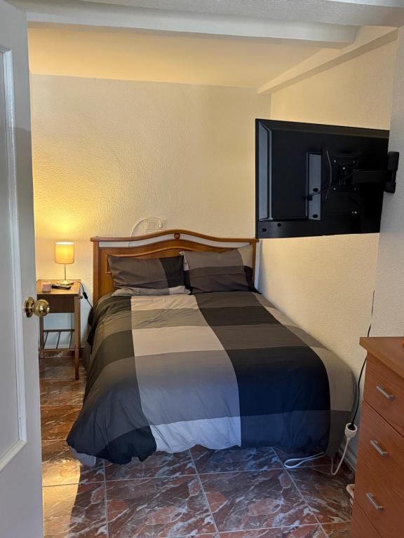 a bedroom with a bed with a tv on the wall at Nobleza Nava del Rey in Nava del Rey