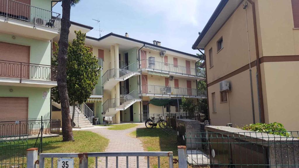 an apartment complex with a walkway between two buildings at Holiday home in Rosolina Mare 33985 in Rosolina Mare