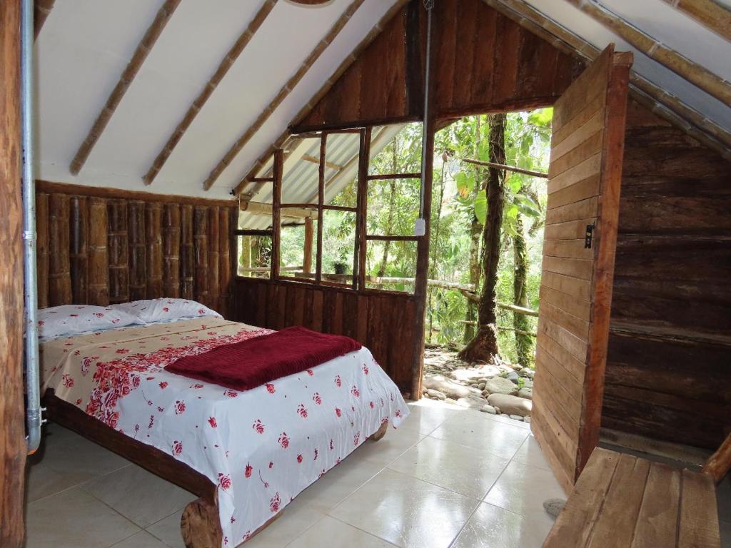 a bedroom with a bed and a large window at Manacus 