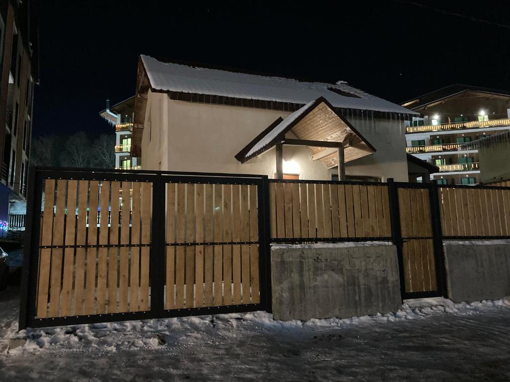 巴库里阿尼Cottage Bakhuta Bakuriani的雪中房子前面的大门