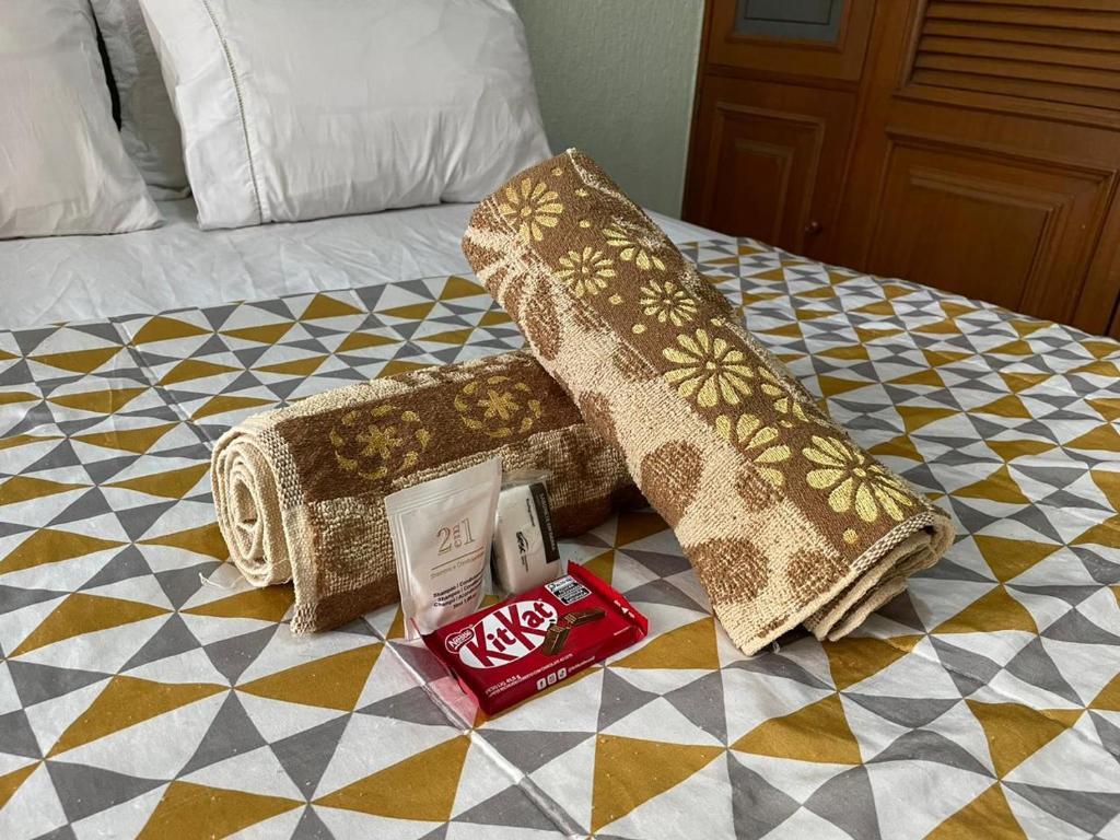 een bed met een deken en kussens erop bij Apartamento Inteiro na Praia de Icaraí com Vista in Niterói