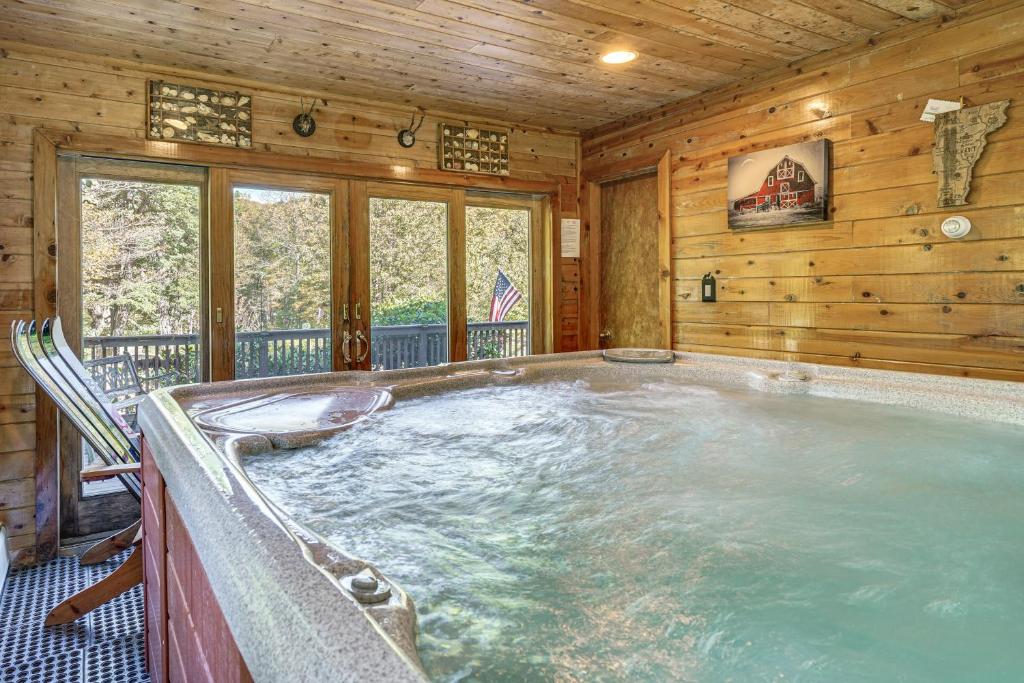 a jacuzzi tub in a log cabin at Riverfront Home with Hot Tub Near Killington Resort in West Bridgewater