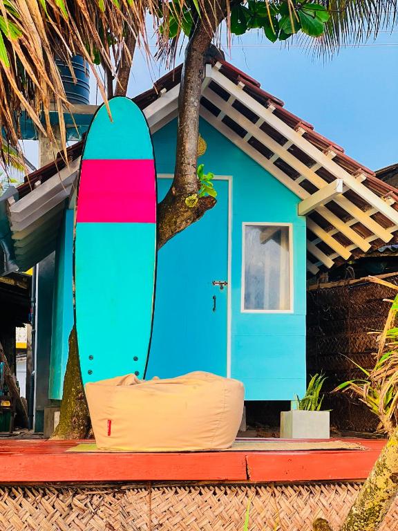 a surfboard sitting in front of a house at Ayaan Beach Home in Dodanduwa