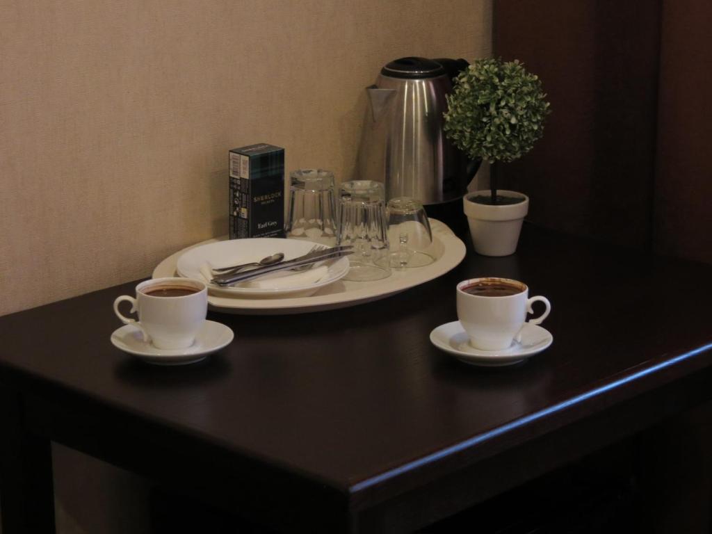 two cups of coffee sitting on a table with a plate at Just comfort in Odesa