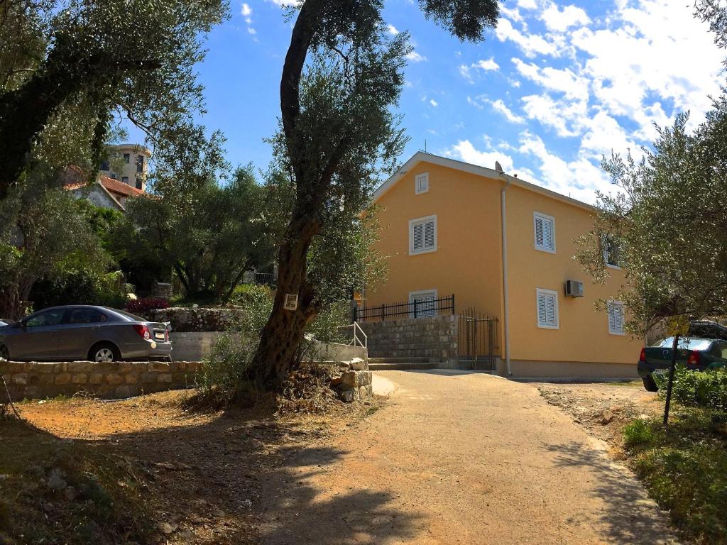 a yellow house with a tree in front of it at Žanjice Luxury Suite in Luštica