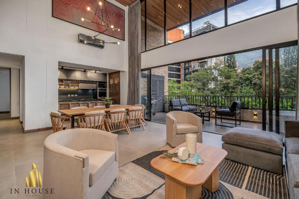 ein offenes Wohnzimmer mit Tischen und Stühlen in der Unterkunft Morph 401 - Modern apt High Ceilings BBQ/Jacuzzi in El Poblado