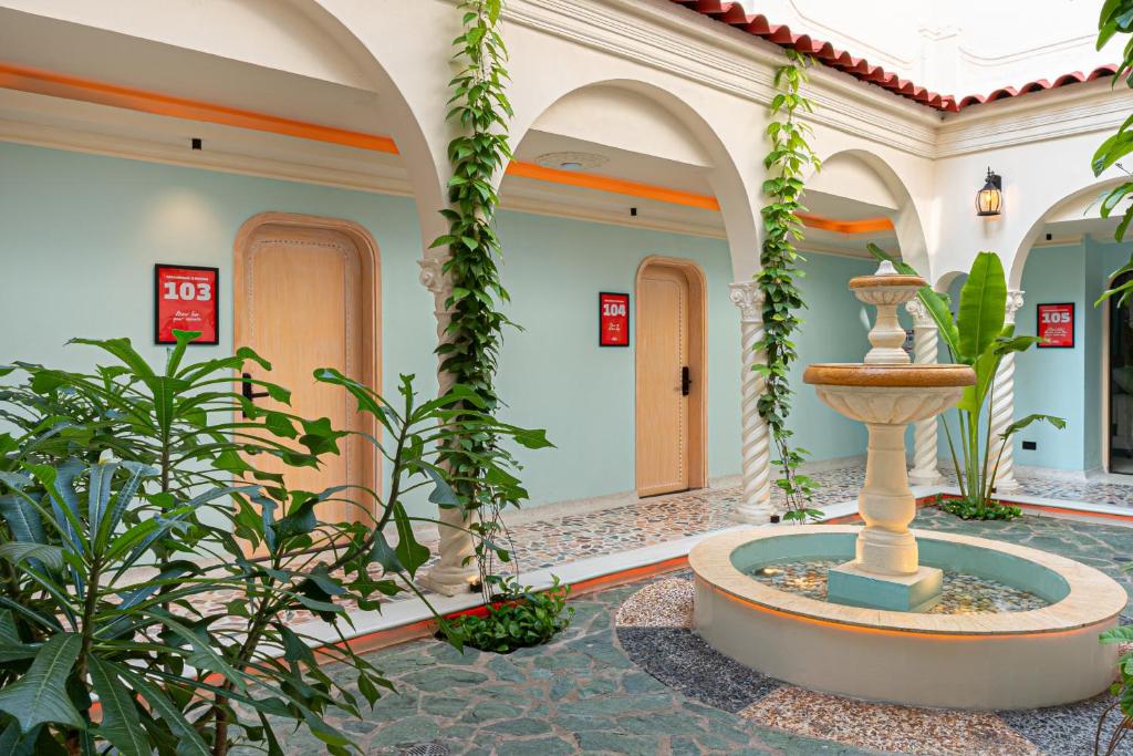 a fountain in the middle of a building with plants at Casa Stella Rooms in Cartagena de Indias
