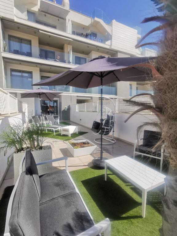 a patio with a white bench and an umbrella at Buddha house in Torrox Costa