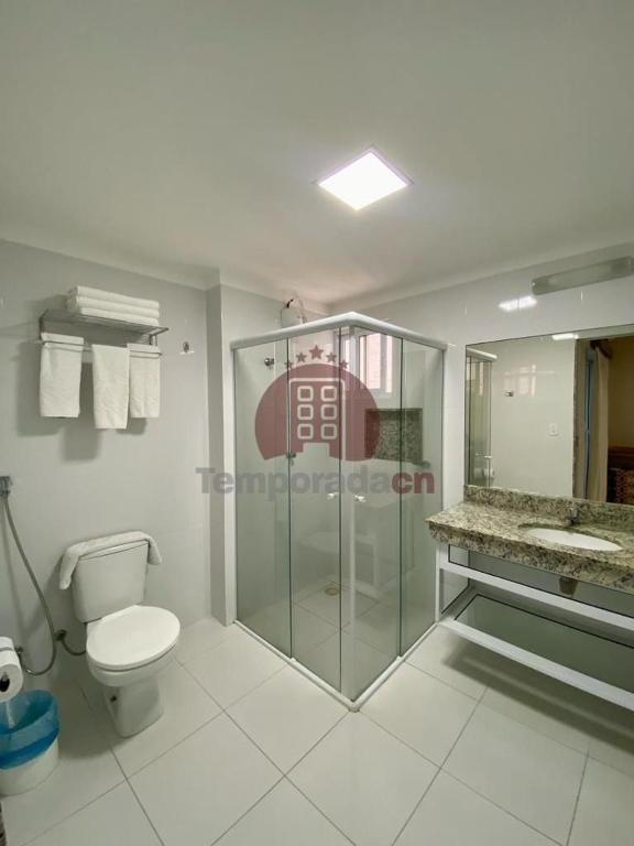 a bathroom with a toilet and a glass shower at Piazza diRoma com acesso ao Acqua Park - Temporada CN in Caldas Novas