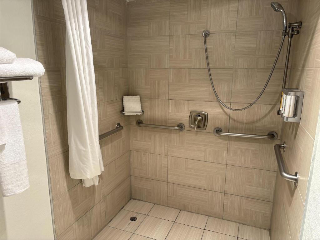 a shower stall in a bathroom with a shower curtain at Best Western InnSuites Phoenix Hotel & Suites in Phoenix