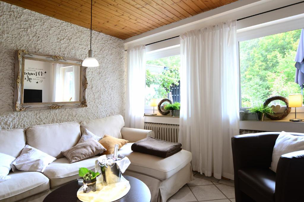 a living room with a white couch and a table at Haus Sonnenschein in Wiltingen