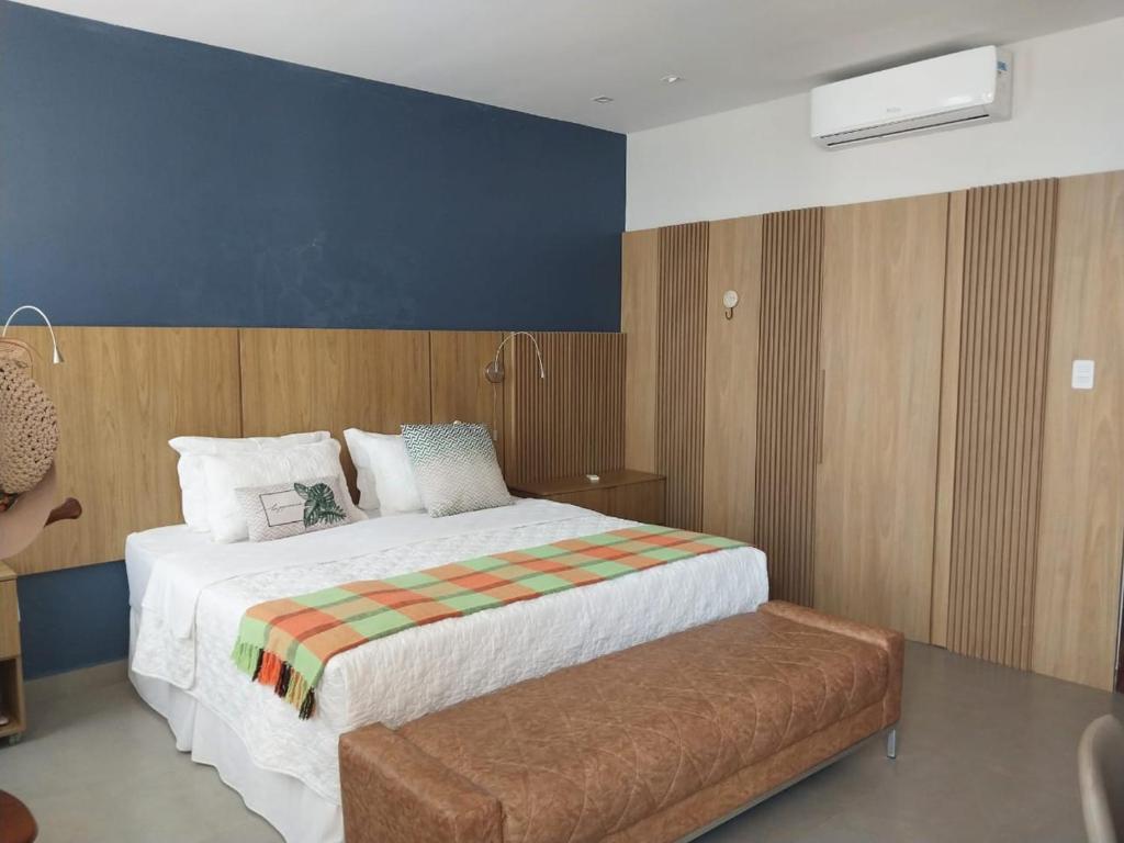 a bedroom with a large bed and a bench at Casa da Orla in Santarém