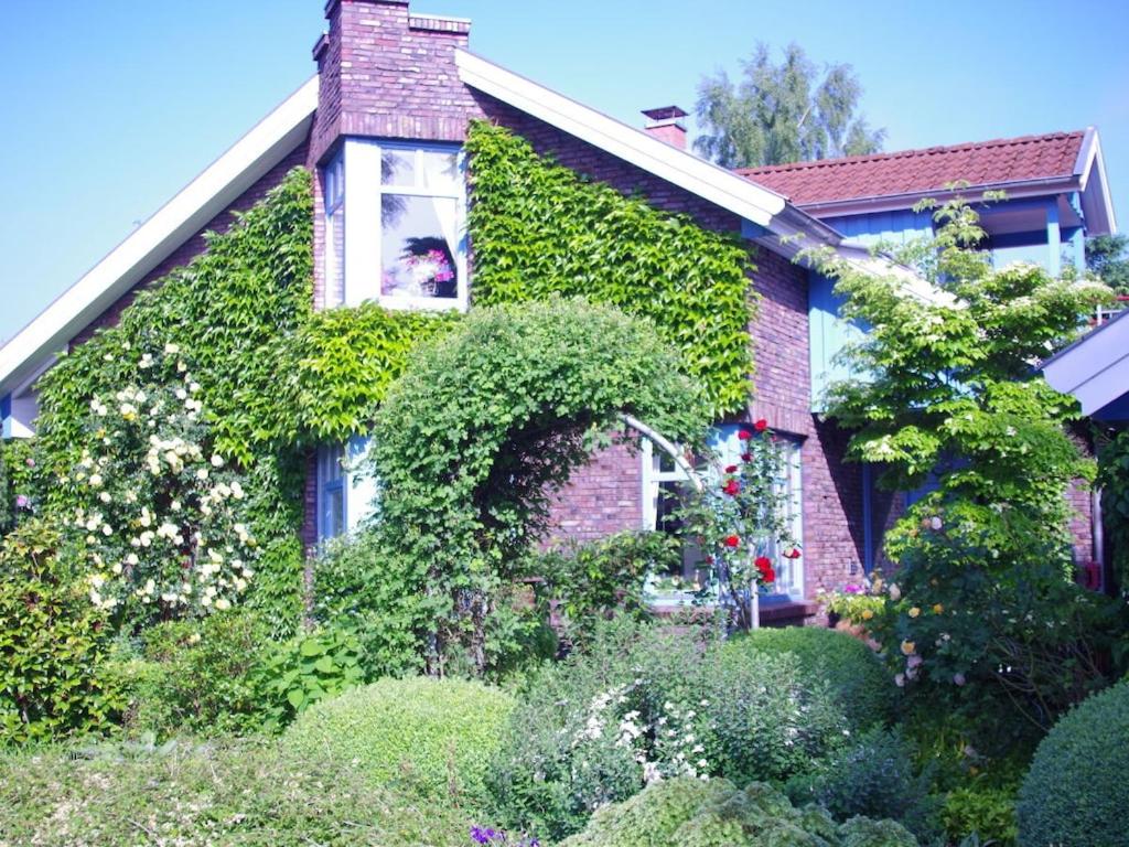 a house covered in green ivy with a window at Holiday Apartment Northern Lights in Oldenburg