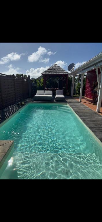 a swimming pool with blue water in front of a house at Villa malaurelia in Saint-François