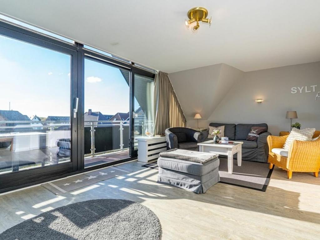 een woonkamer met een bank en een tafel bij One-bedroom apartment in Wenningstedt