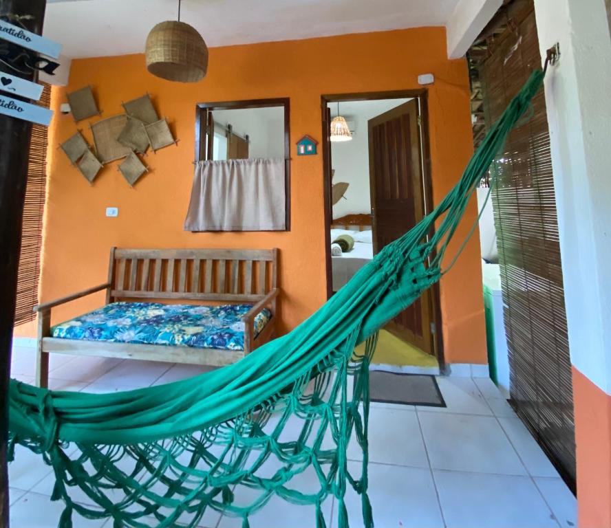 a hammock in a room with a bedroom at Pousada Clara Caraíva in Caraíva