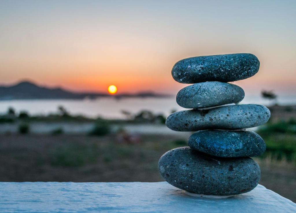 a stack of rocks sitting on top of a sunset at Agnanti View Hotel in Pachaina
