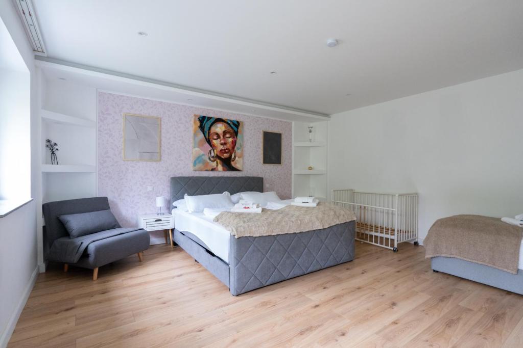 una camera da letto con un letto e una sedia di Near Vienna - 80m2 - Garden - Near Vienna - Workers&Families a Purkersdorf