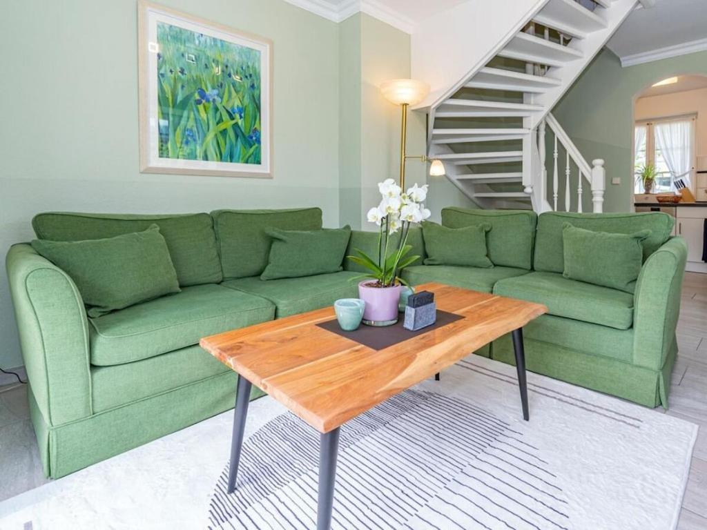 a living room with a green couch and a coffee table at Island pearl in the Horsatal in Wenningstedt