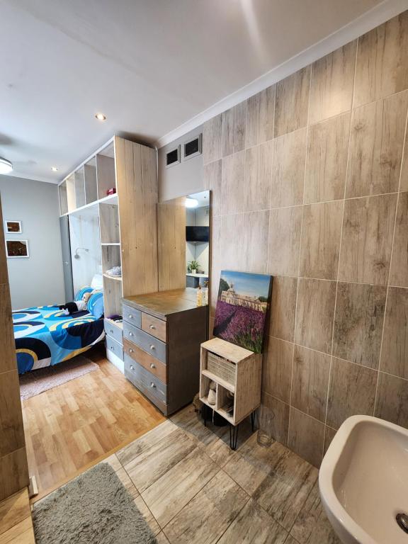 a bathroom with a sink and a bedroom with a bed at Maple Tree Manor in Durban
