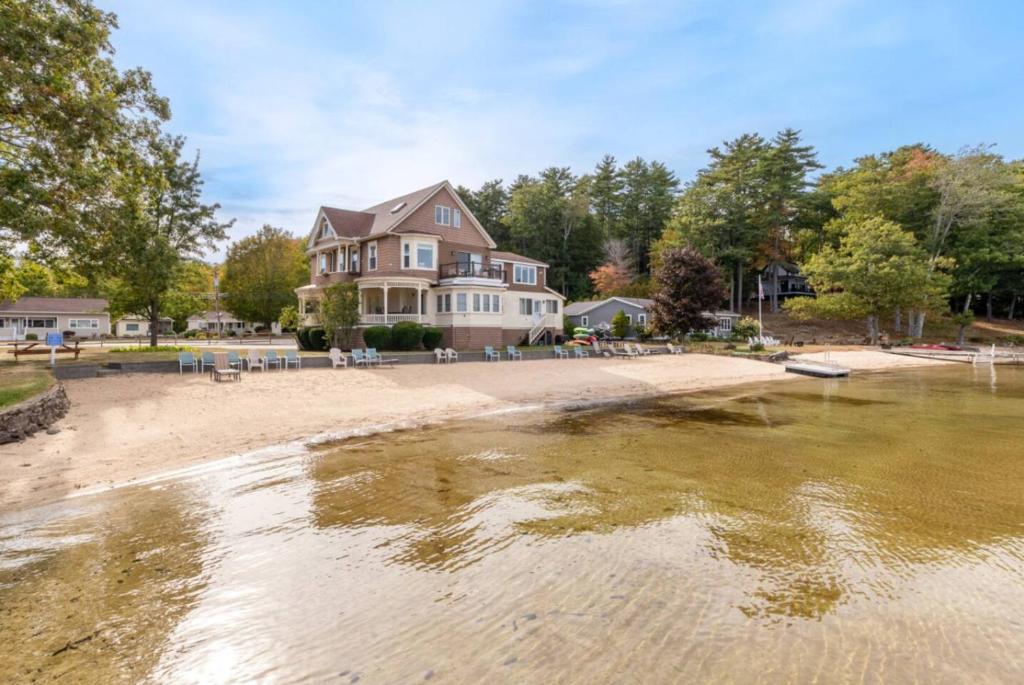 a house on the shore of a body of water at Sunny Shores - Lake days, Pool dips & Concerts in Dockham Shore