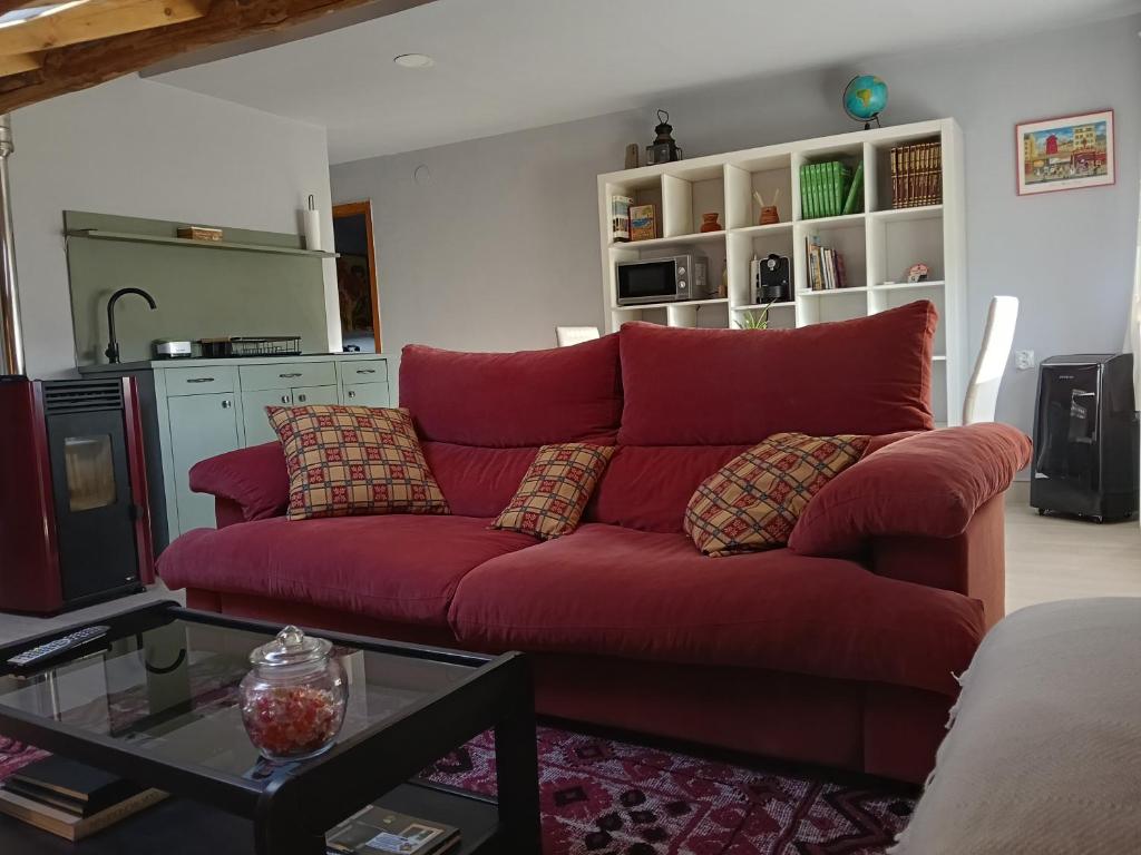a red couch in a living room with a table at Apartamento Riazón3 in Ourense