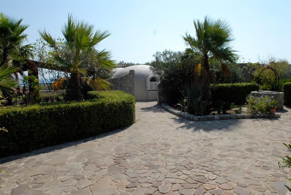 a courtyard with palm trees and a building at Villa Sebastian- Incomparabile vista sul mare in Siracusa