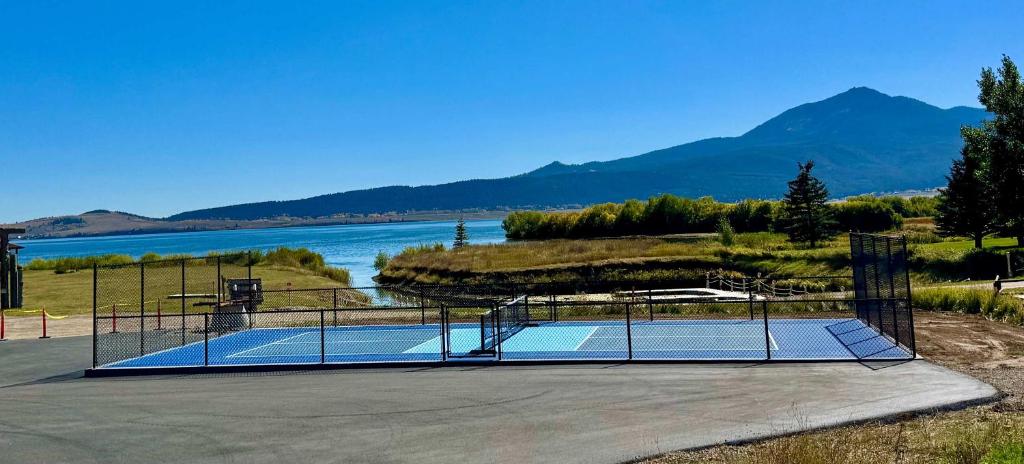 a tennis court next to a body of water at Henrys Lake Walkout Cabin in Staley Springs