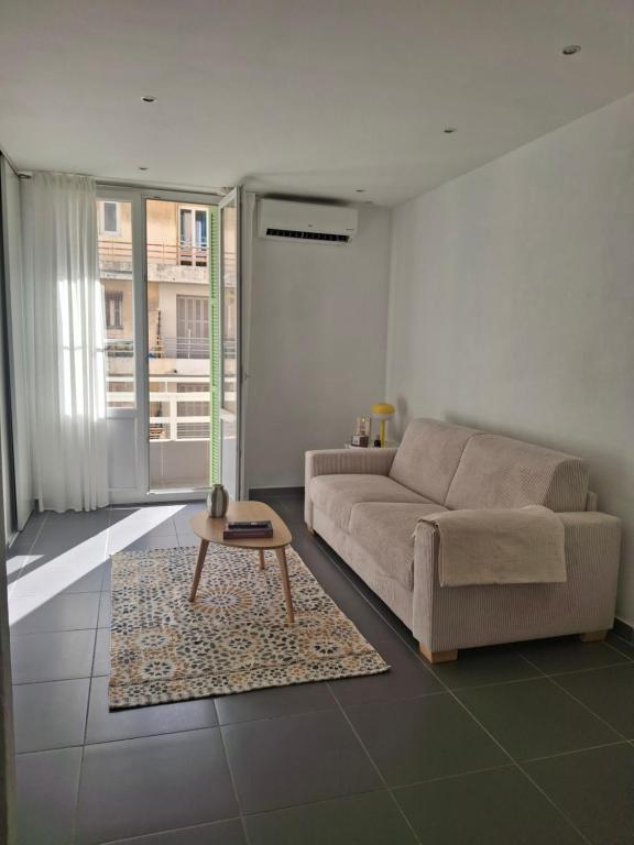 a living room with a couch and a coffee table at Joli T1 bis - Centre ville in Bastia