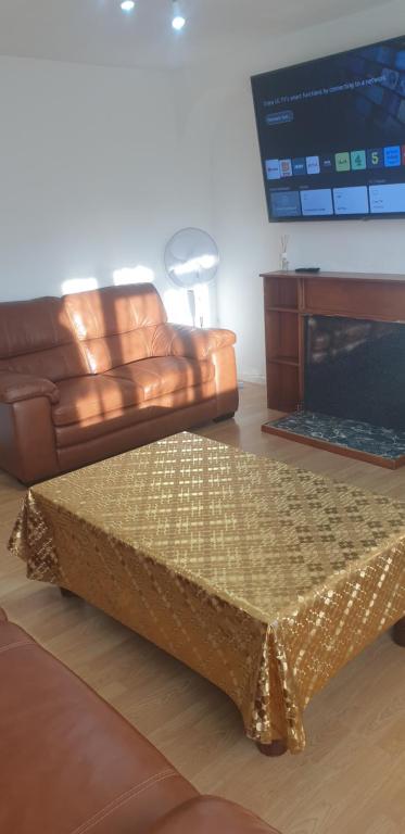 un salon avec un canapé en cuir et une table dans l'établissement Lovely Room in the Heart of London, à Maida Vale