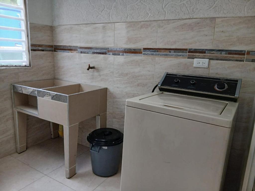a kitchen with a sink and a washing machine at El Mirador de La Buitrera Paz entre Montañas in Palmira